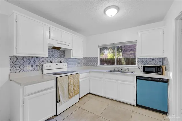 a kitchen with a sink stove and cabinets