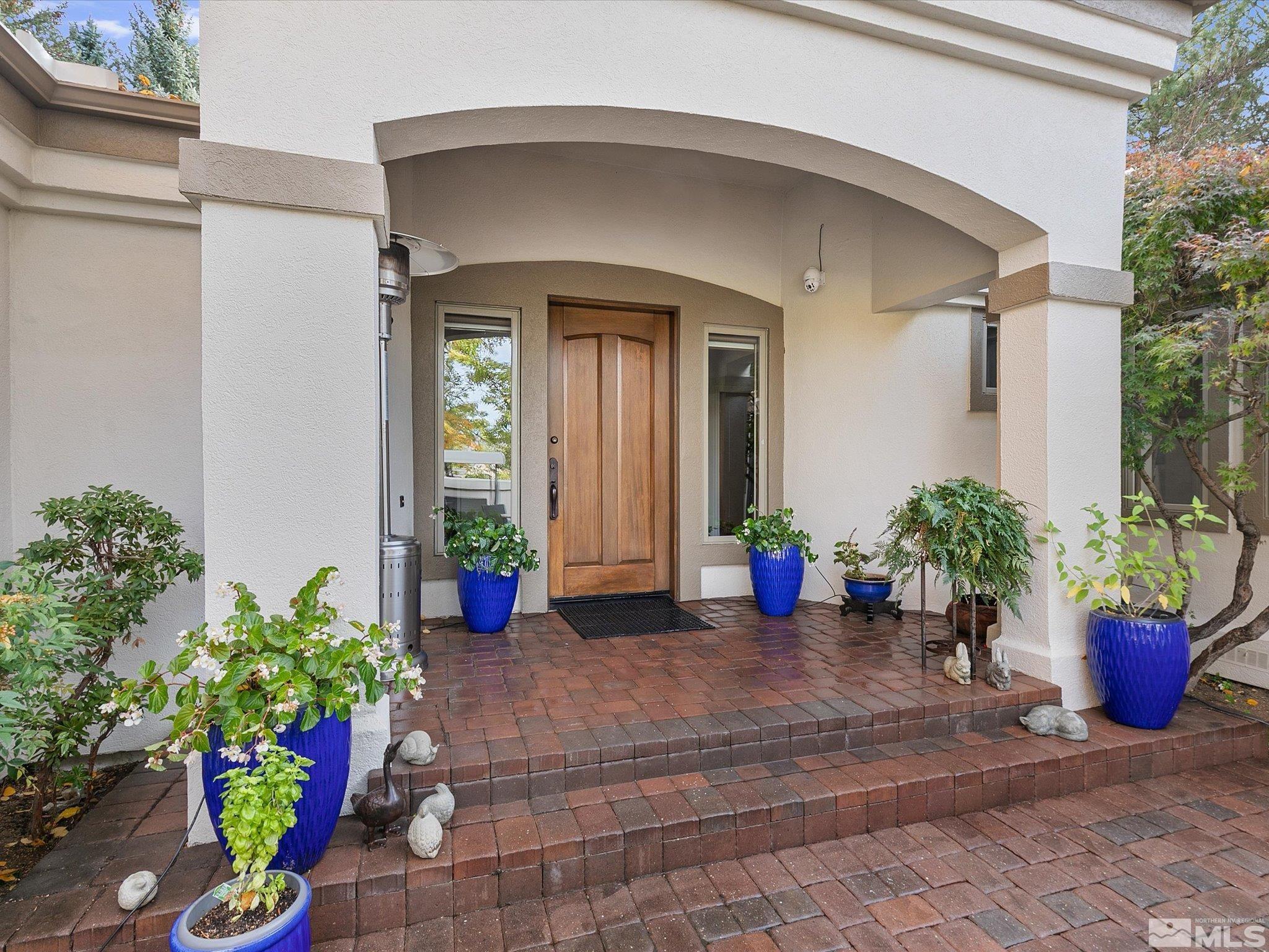 100 Sawbuck Road Reno, NV 89519 - Photo 5 of 40 a view of a house with potted plants and a bench