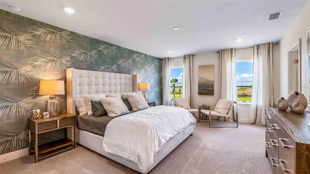 a bedroom with a bed and large windows