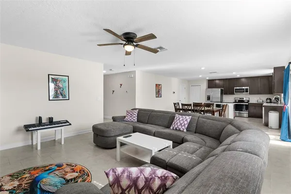 a living room with furniture kitchen view and a window