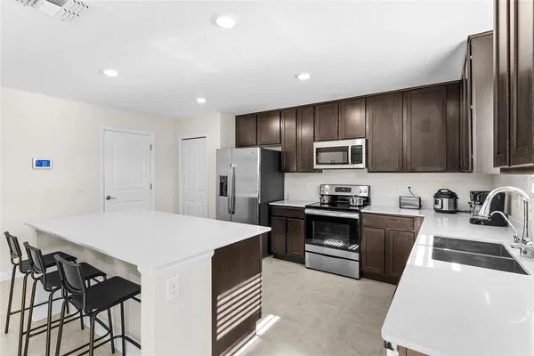 a kitchen with stainless steel appliances a stove refrigerator sink and microwave