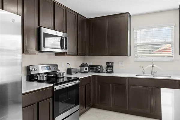 a kitchen with stainless steel appliances granite countertop a sink stove and microwave
