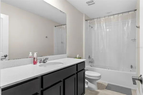 a bathroom with a sink a toilet and shower curtain