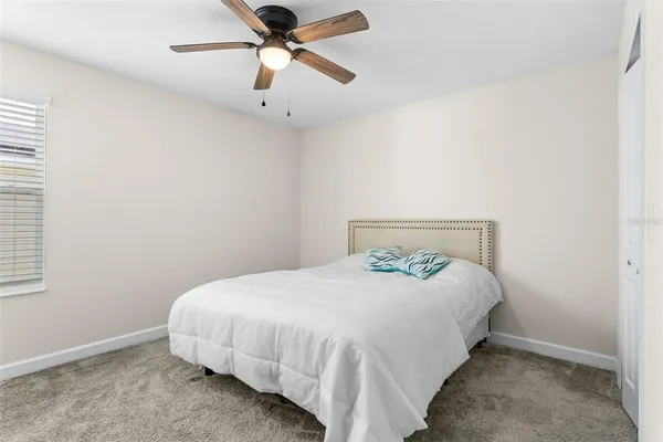 a bedroom with a bed and a ceiling fan