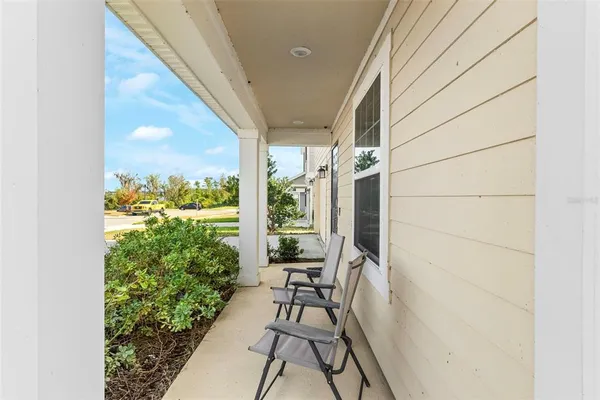 a view of balcony with chairs and potted plants