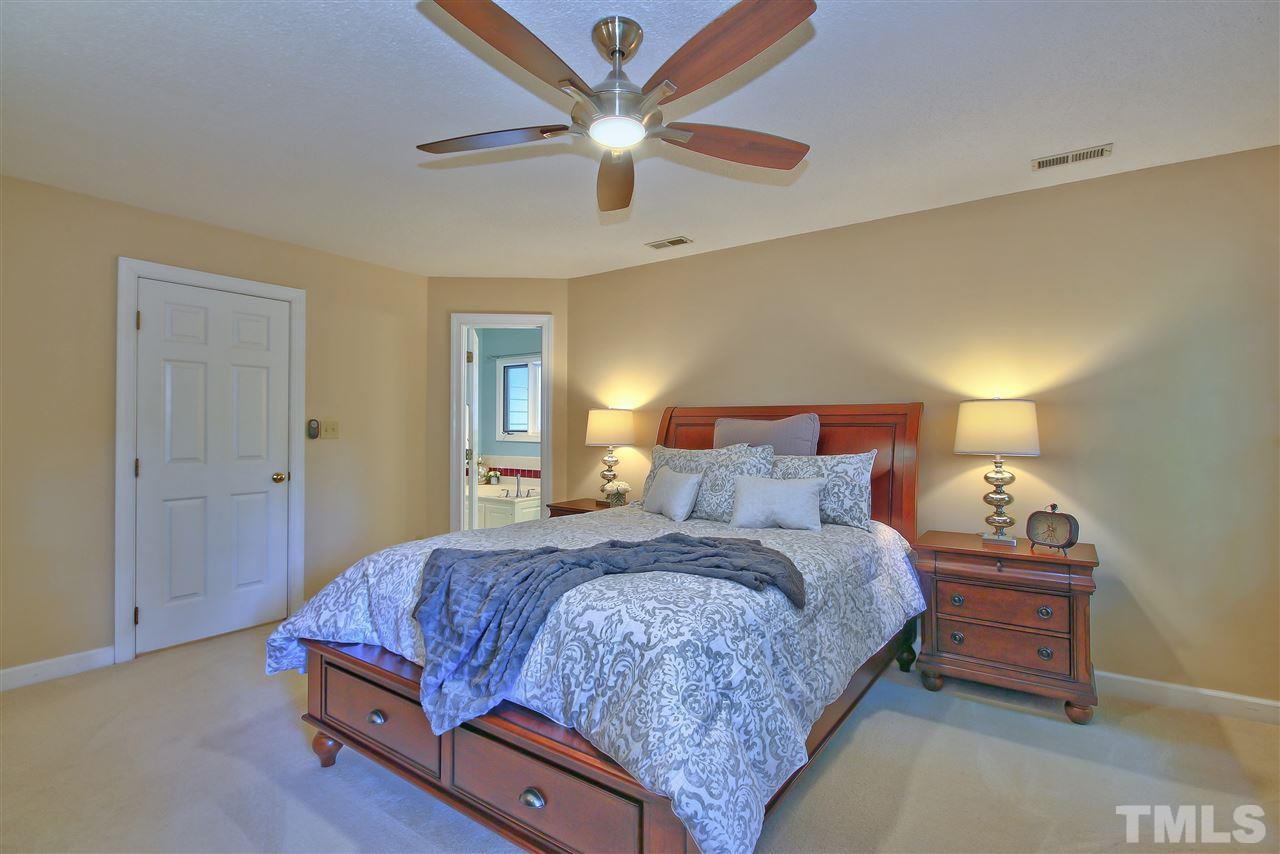 6108 Fetlock Drive Raleigh, NC 27613 - Photo 14 of 25 a bedroom with a bed and a ceiling fan