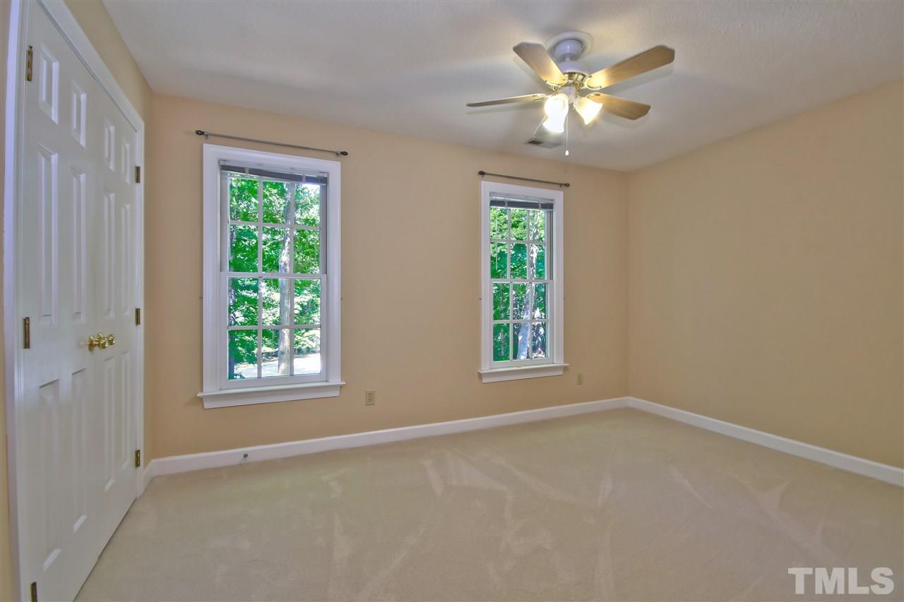6108 Fetlock Drive Raleigh, NC 27613 - Photo 18 of 25 an empty room with windows and chandelier fan