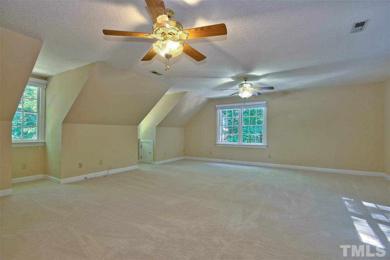 6108 Fetlock Drive Raleigh, NC 27613 - Photo 21 of 25 an empty room with windows and chandelier fan