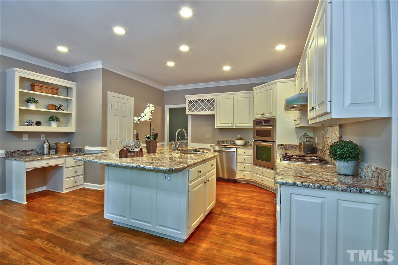 6108 Fetlock Drive Raleigh, NC 27613 - Photo 8 of 25 a kitchen with stainless steel appliances granite countertop sink stove top oven and cabinets