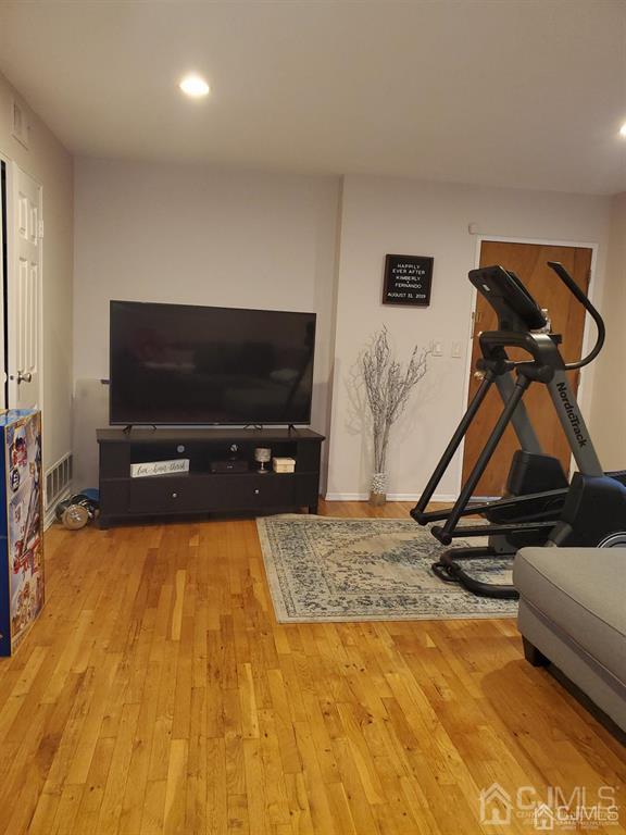 18 Judson Street, Unit 3A Edison, NJ 08837 - Photo 8 of 13 a living room with gym equipment and a flat screen tv