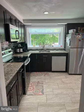 a kitchen with stainless steel appliances granite countertop a stove sink and microwave