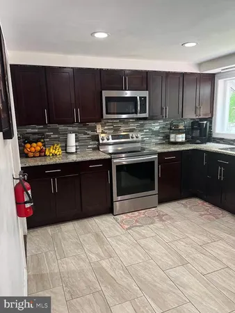 a kitchen with stainless steel appliances granite countertop a stove a sink dishwasher and a microwave