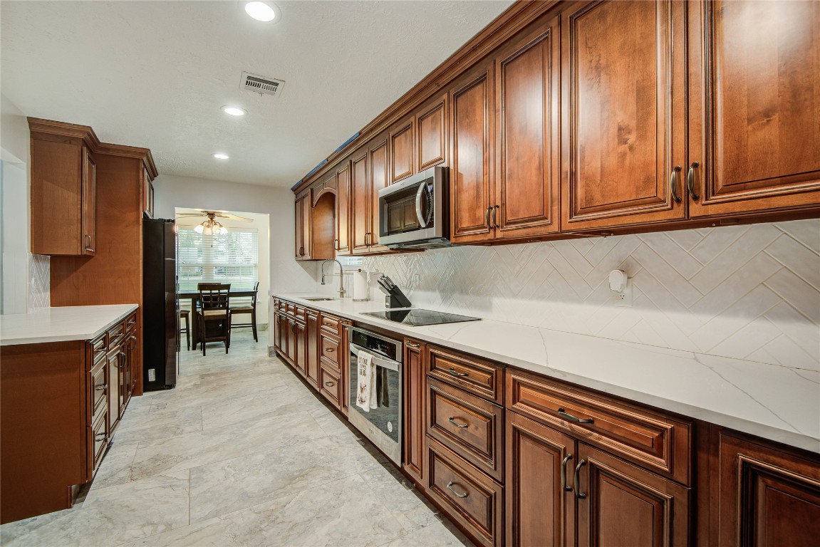 25910 Maplewood Drive Spring, TX 77386 - Photo 16 of 50 a kitchen with stainless steel appliances granite countertop a stove a sink and a microwave