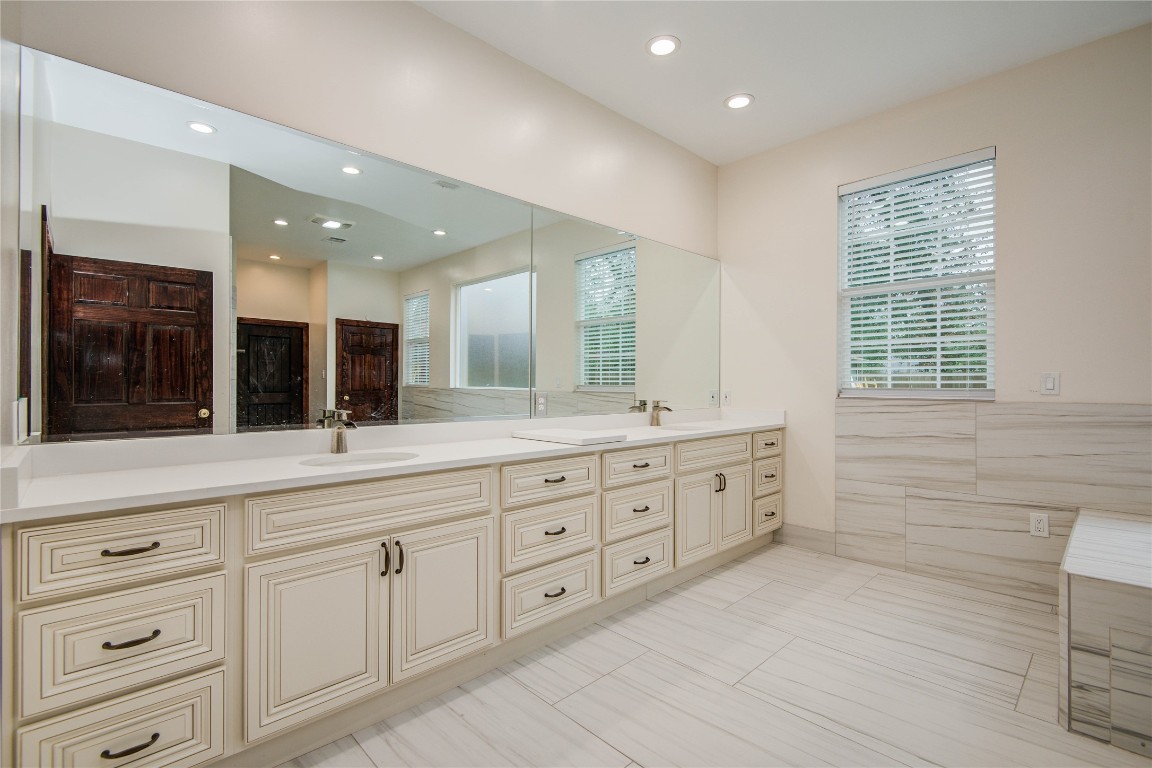 25910 Maplewood Drive Spring, TX 77386 - Photo 29 of 50 a bathroom with double vanity sink a two mirror a window and a bathtub