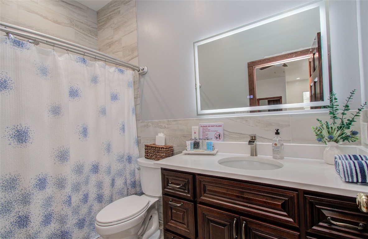 25910 Maplewood Drive Spring, TX 77386 - Photo 48 of 50 a bathroom with a sink toilet a mirror and shower curtain