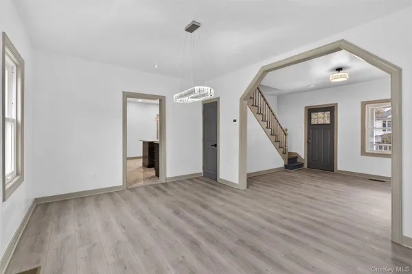 an empty room with wooden floor and a ceiling fan