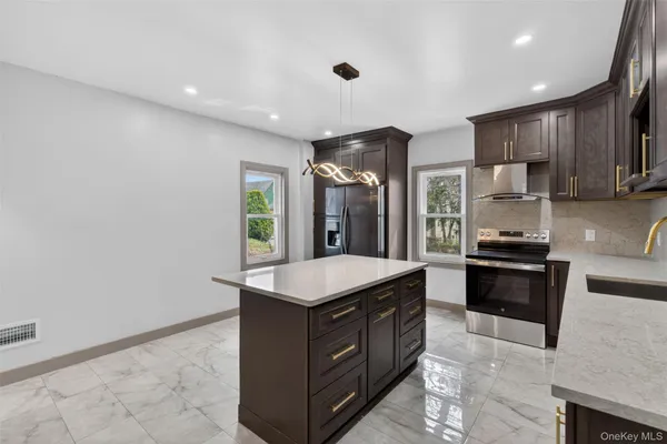 a kitchen with stainless steel appliances granite countertop a stove a sink and a refrigerator