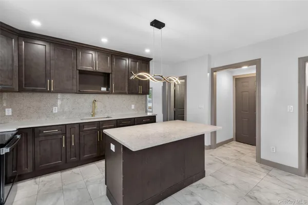 a kitchen with stainless steel appliances a refrigerator a sink a stove a microwave and wooden cabinets