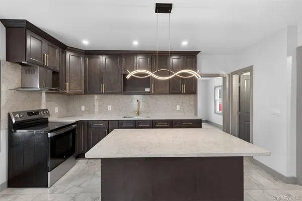 a kitchen with stainless steel appliances granite countertop a sink a stove and a refrigerator