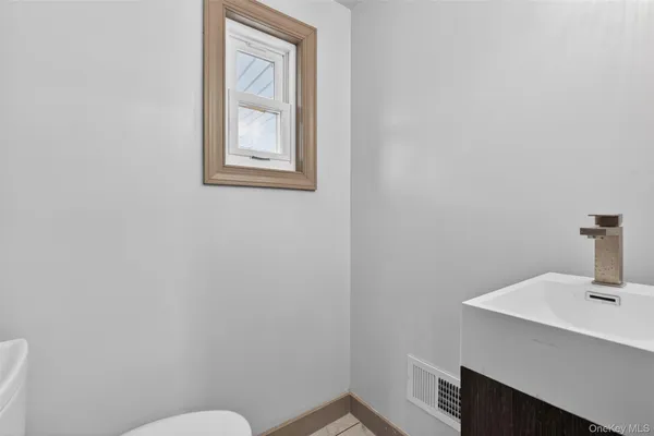 a bathroom with a sink mirror and toilet