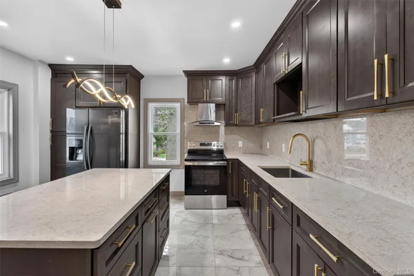 a kitchen with stainless steel appliances granite countertop a sink a stove and a refrigerator