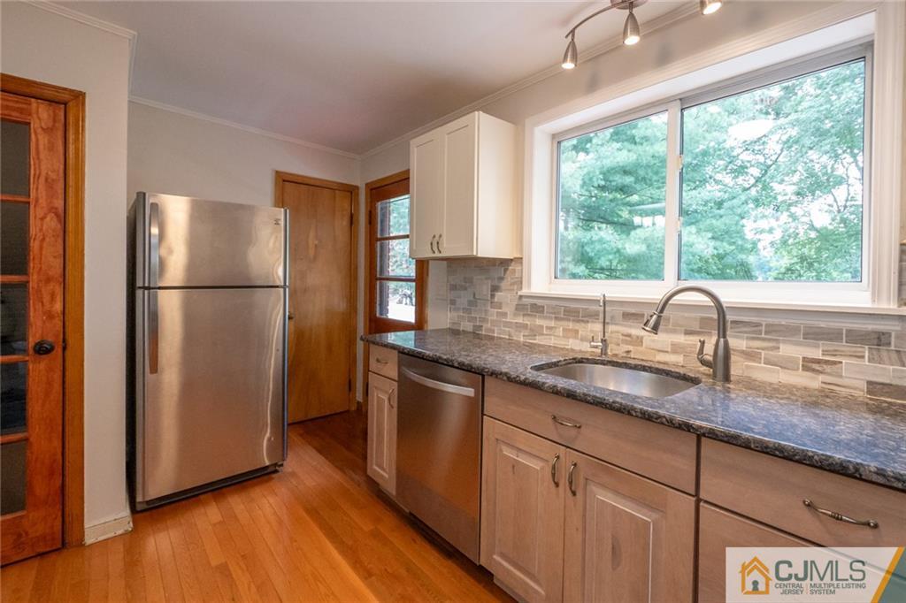 94 Oxford Road Colonia, NJ 07067 - Photo 14 of 27 a kitchen with granite countertop stainless steel appliances a refrigerator sink and wooden floor