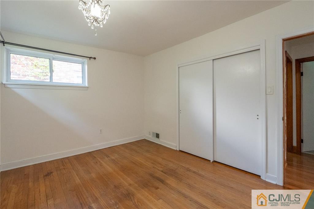 94 Oxford Road Colonia, NJ 07067 - Photo 18 of 27 a view of an empty room with wooden floor and a window
