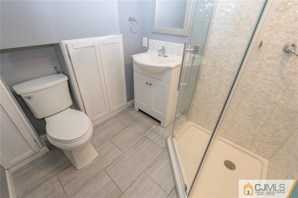 94 Oxford Road Colonia, NJ 07067 - Photo 22 of 27 a white toilet sitting next to a white sink and vanity