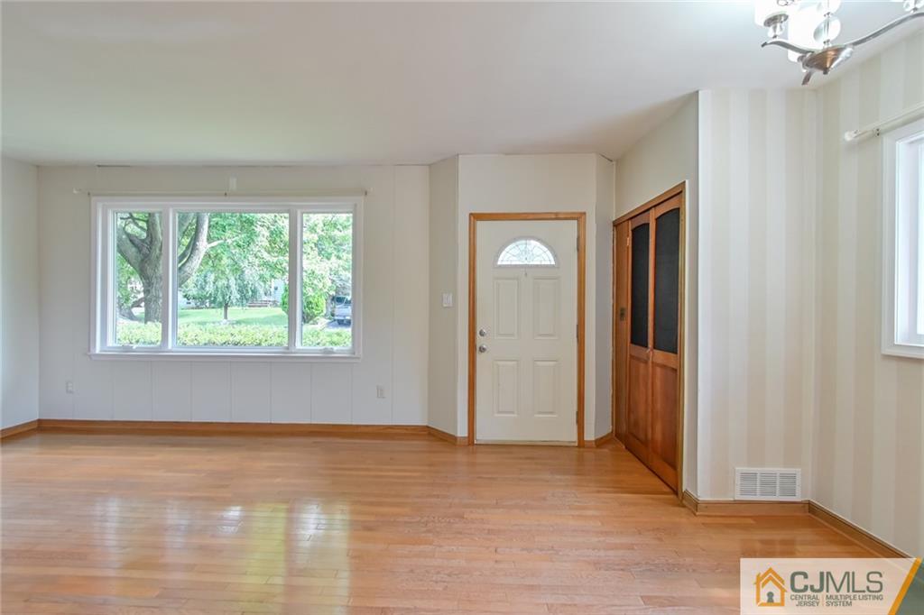 94 Oxford Road Colonia, NJ 07067 - Photo 5 of 27 a view of an empty room with wooden floor and a window