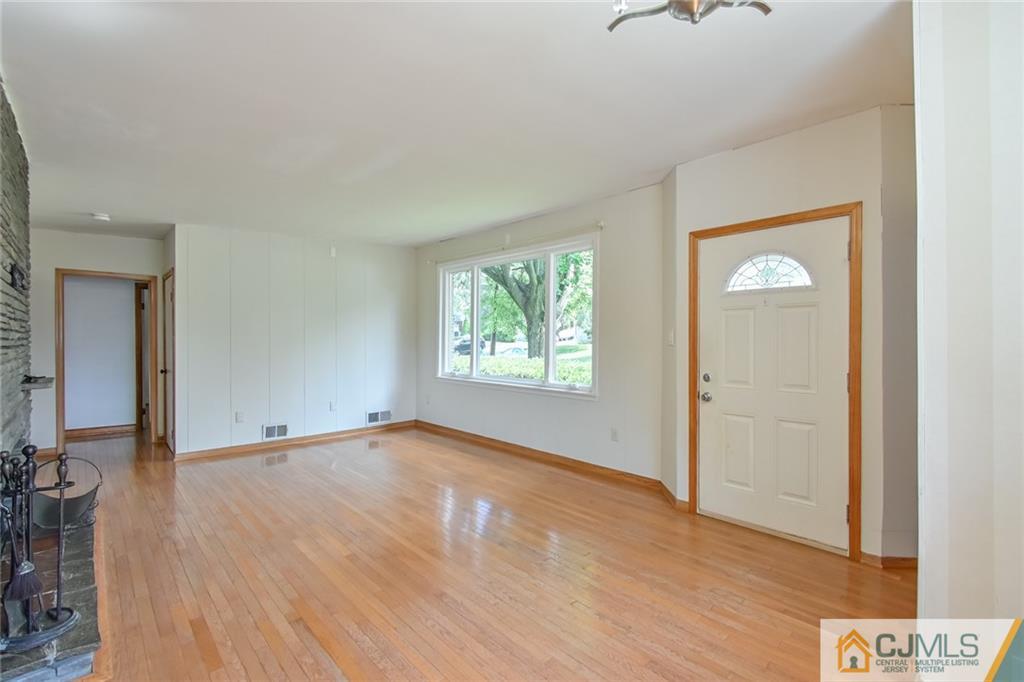 94 Oxford Road Colonia, NJ 07067 - Photo 6 of 27 an empty room with wooden floor and windows