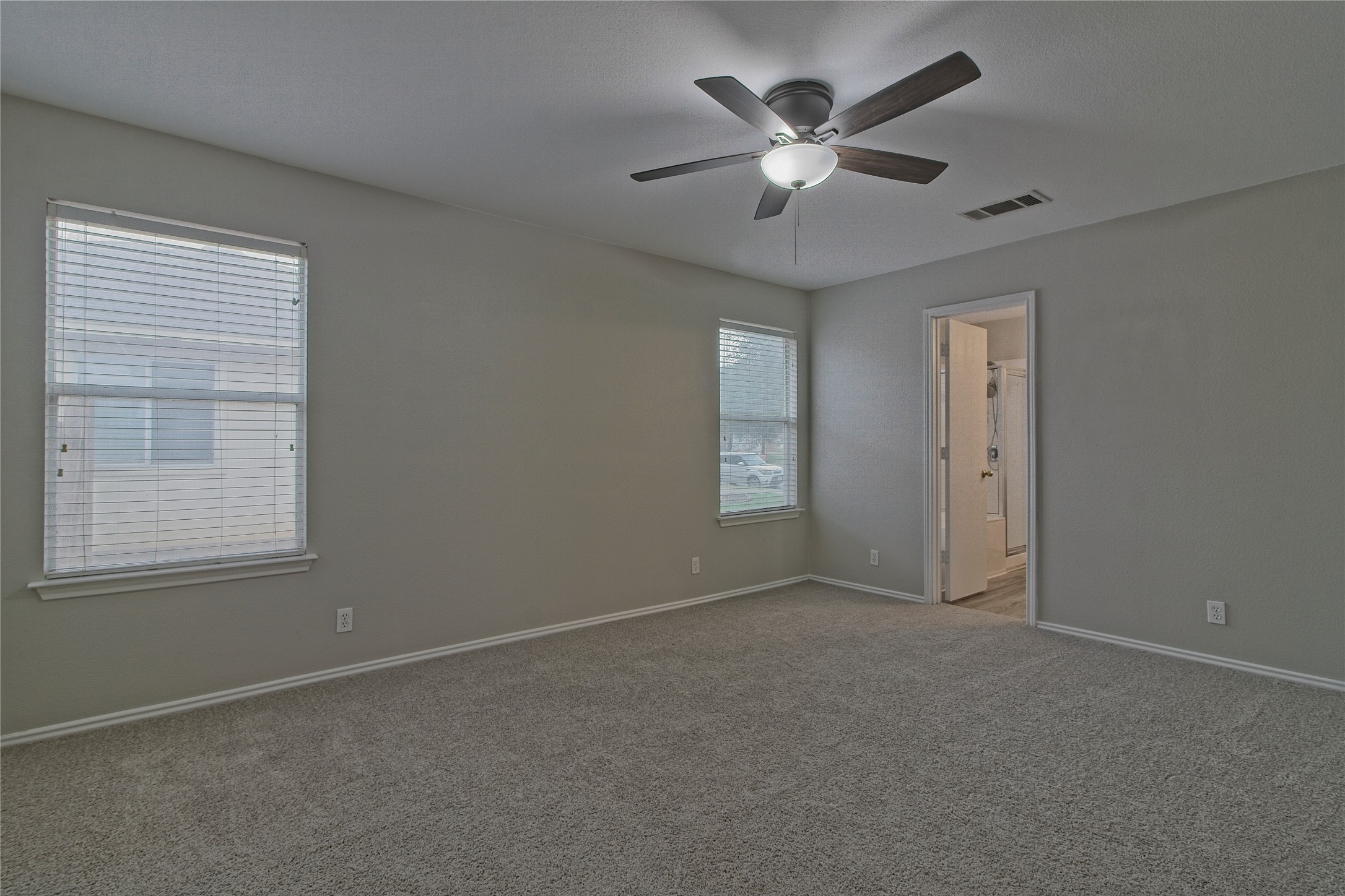232 Brickyard Lane Jarrell, TX 76537 - Photo 18 of 31 Comfortable master bedroom featuring plush carpeting and a modern ceiling fan with lighting.