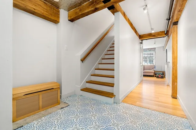 a view of a hallway with entryway and stairs