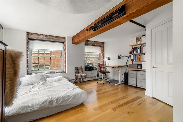 a spacious bedroom with a bed a table and a large window