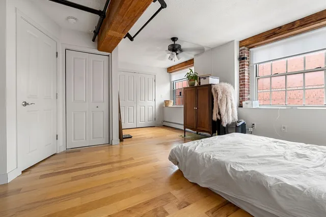 a bedroom with a bed and wooden floor
