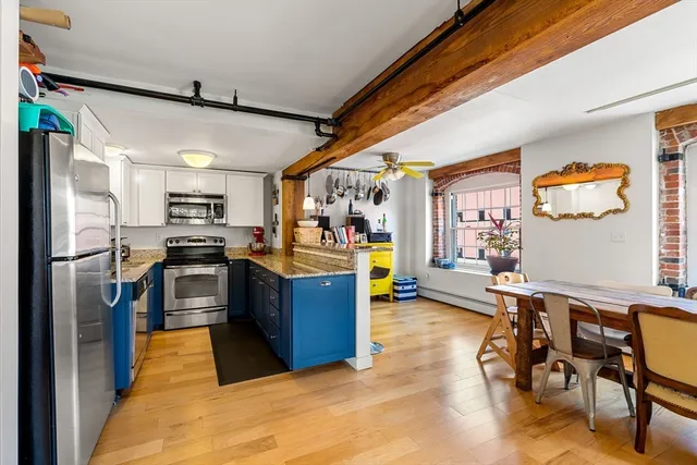 a kitchen with stainless steel appliances kitchen island granite countertop a refrigerator and a stove top oven