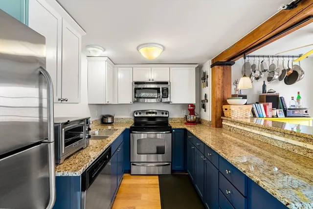 a kitchen with stainless steel appliances granite countertop a sink a stove and a refrigerator