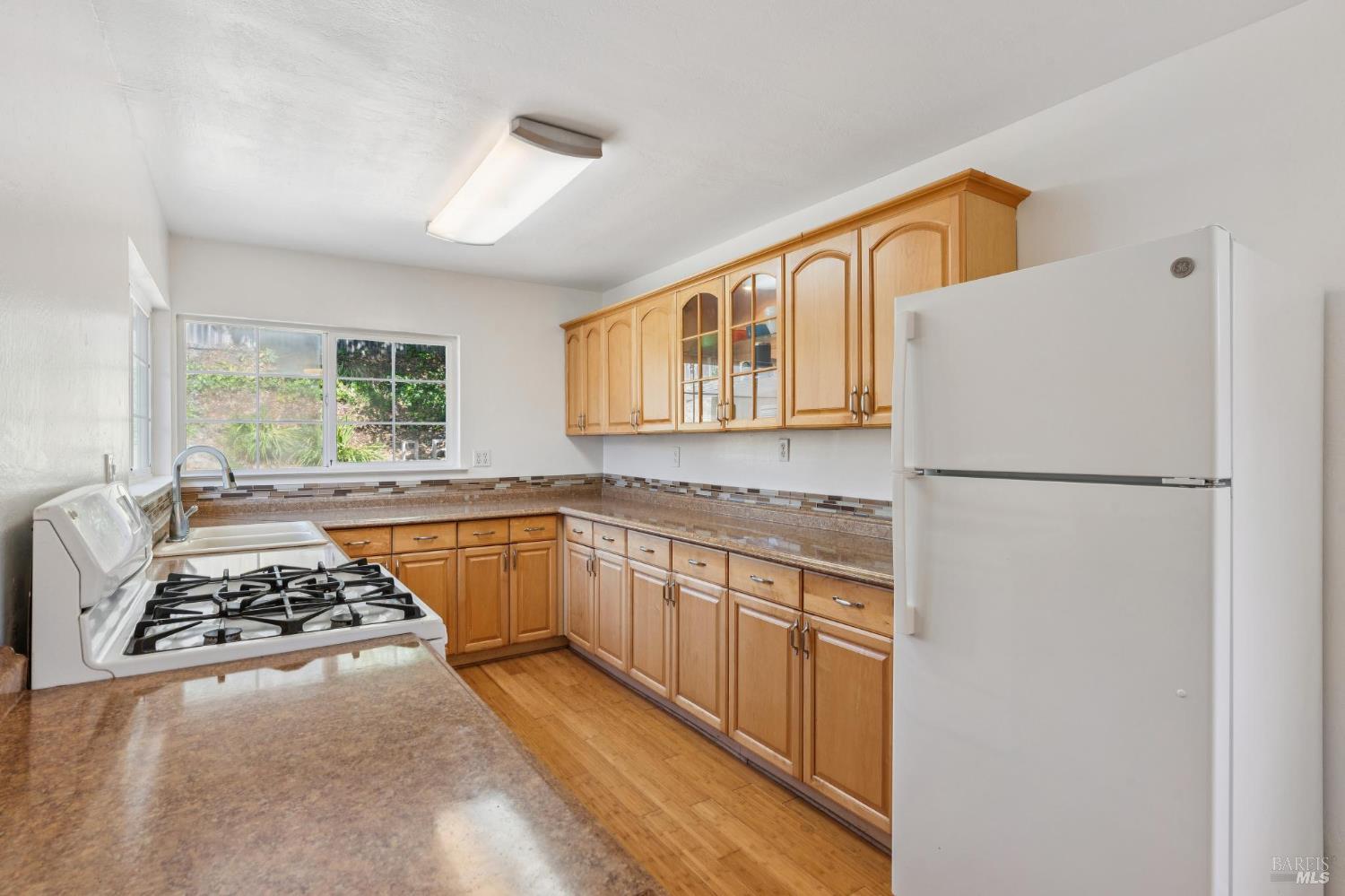 546 Pinewood Drive San Rafael, CA 94903 - Photo 17 of 52 a kitchen with stainless steel appliances granite countertop a refrigerator a sink dishwasher a stove and white countertops with wooden floor