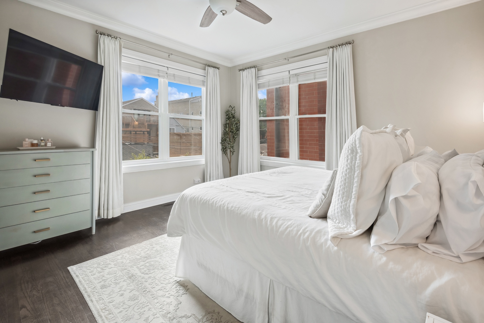 1327 West Roscoe Street, Unit 2 Chicago, IL 60657 - Photo 12 of 32 a bedroom with a bed and a flat tv screen on dresser