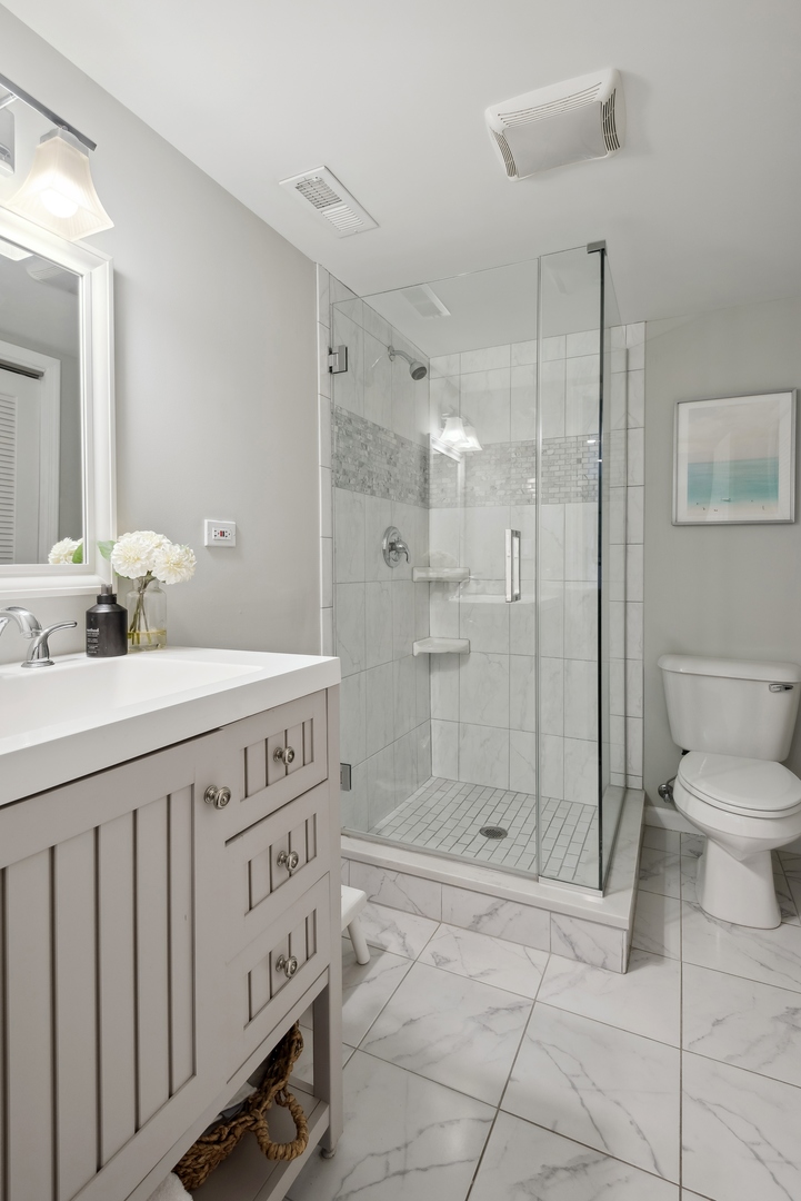 1327 West Roscoe Street, Unit 2 Chicago, IL 60657 - Photo 15 of 32 a bathroom with a sink a toilet and shower