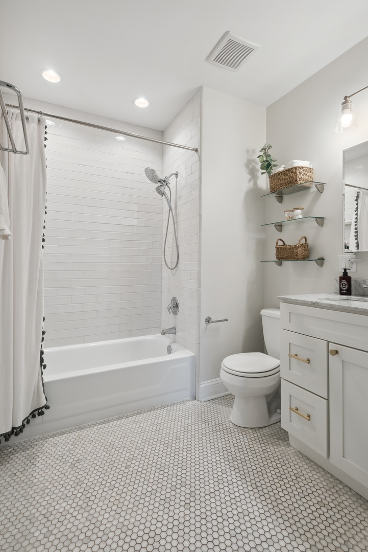 1327 West Roscoe Street, Unit 2 Chicago, IL 60657 - Photo 17 of 32 a bathroom with a toilet a sink and a bathtub