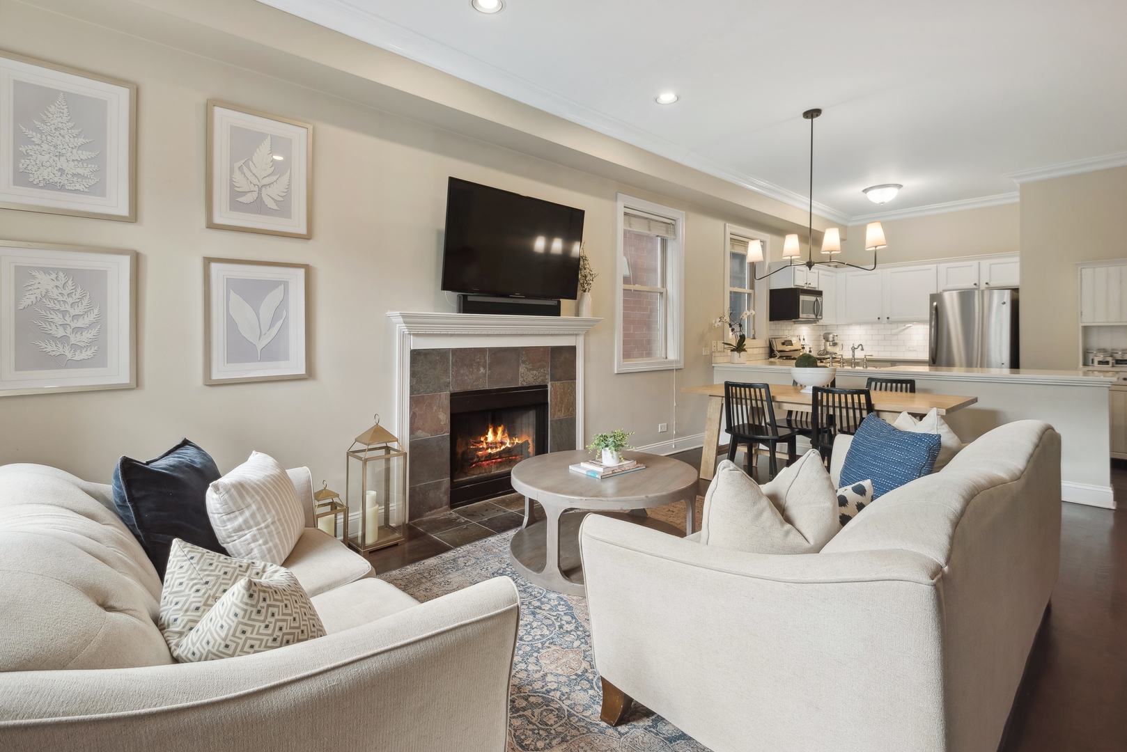 1327 West Roscoe Street, Unit 2 Chicago, IL 60657 - Photo 2 of 32 a living room with furniture a flat screen tv and a fireplace