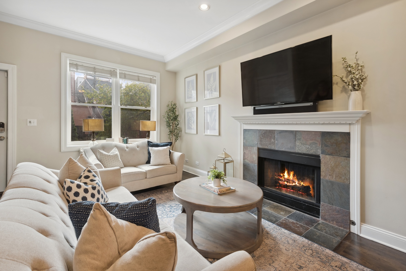 1327 West Roscoe Street, Unit 2 Chicago, IL 60657 - Photo 3 of 32 a living room with furniture a flat screen tv and a fireplace