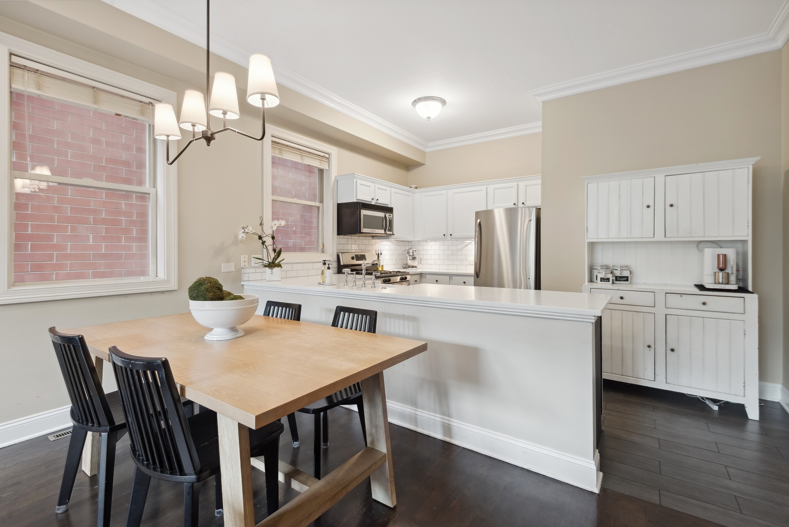 1327 West Roscoe Street, Unit 2 Chicago, IL 60657 - Photo 7 of 32 a kitchen with kitchen island a stove a table and chairs