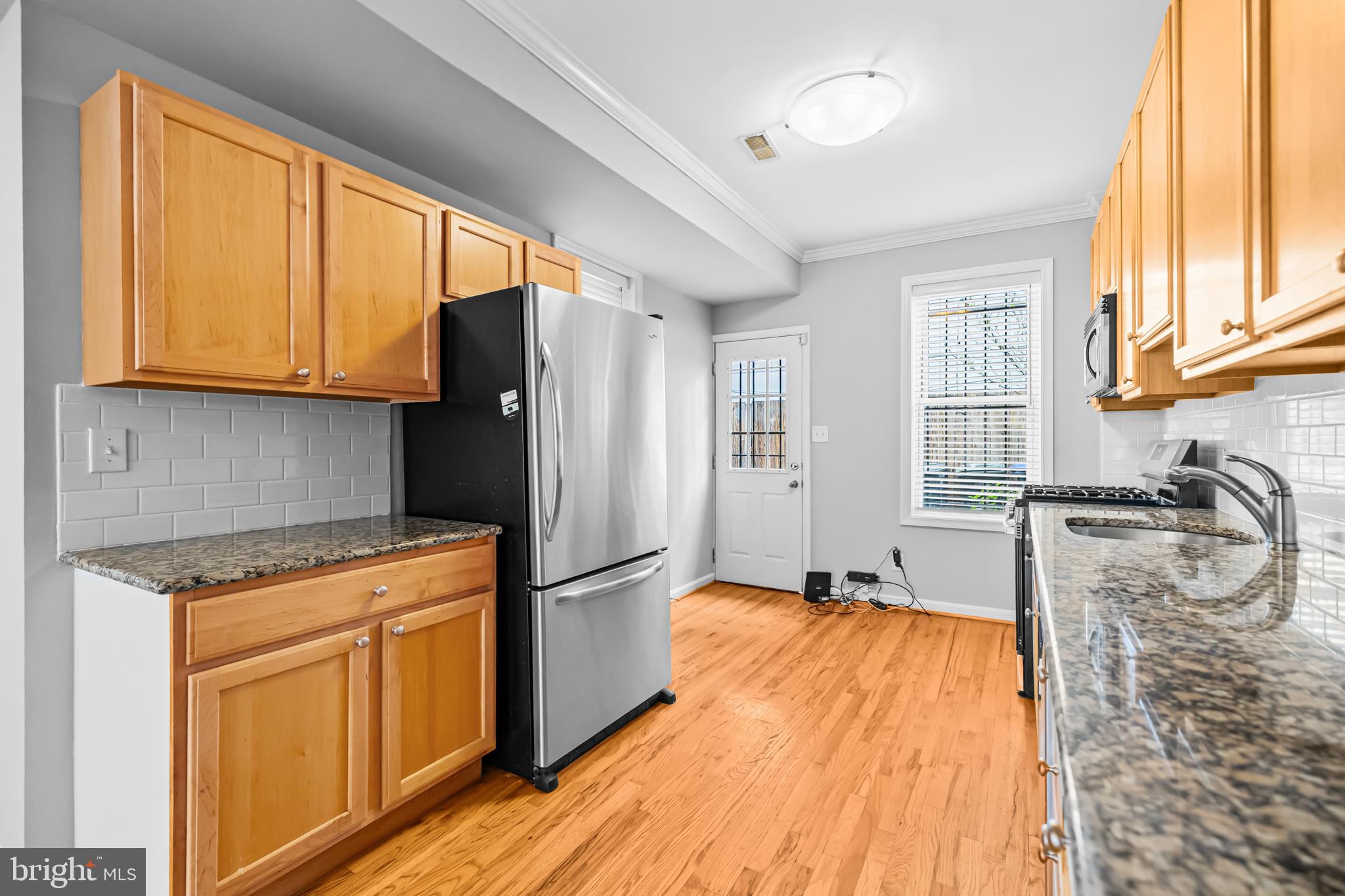 773 Kenyon Street Northwest Washington, DC 20010 - Photo 7 of 17 a kitchen with granite countertop a refrigerator and a sink