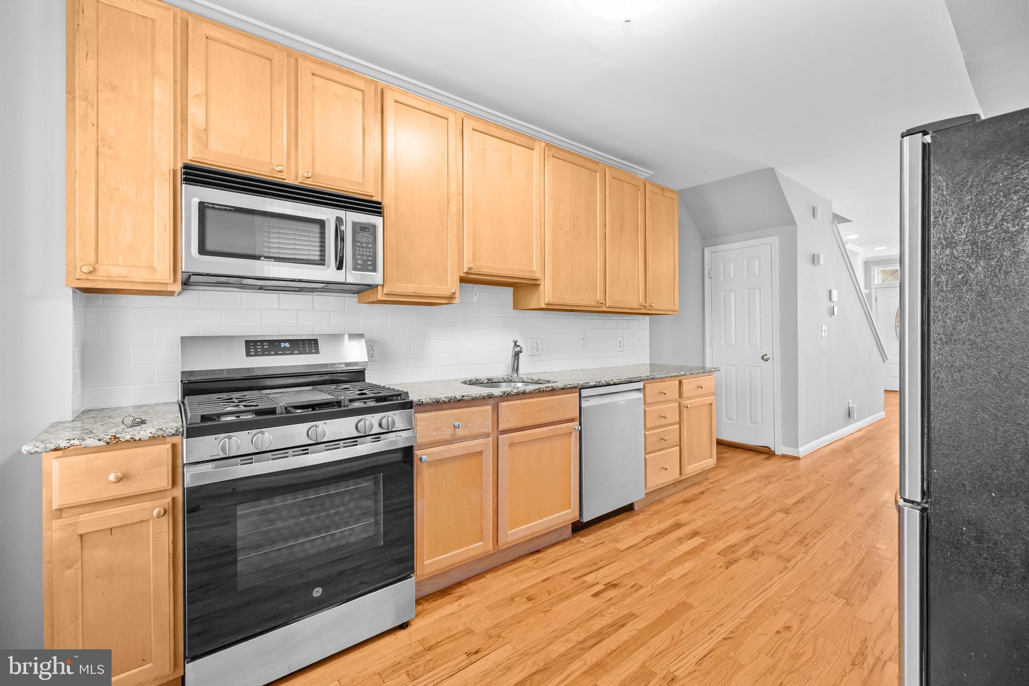 773 Kenyon Street Northwest Washington, DC 20010 - Photo 8 of 17 a kitchen with stainless steel appliances granite countertop a stove top oven a sink dishwasher and a refrigerator with wooden cabinets