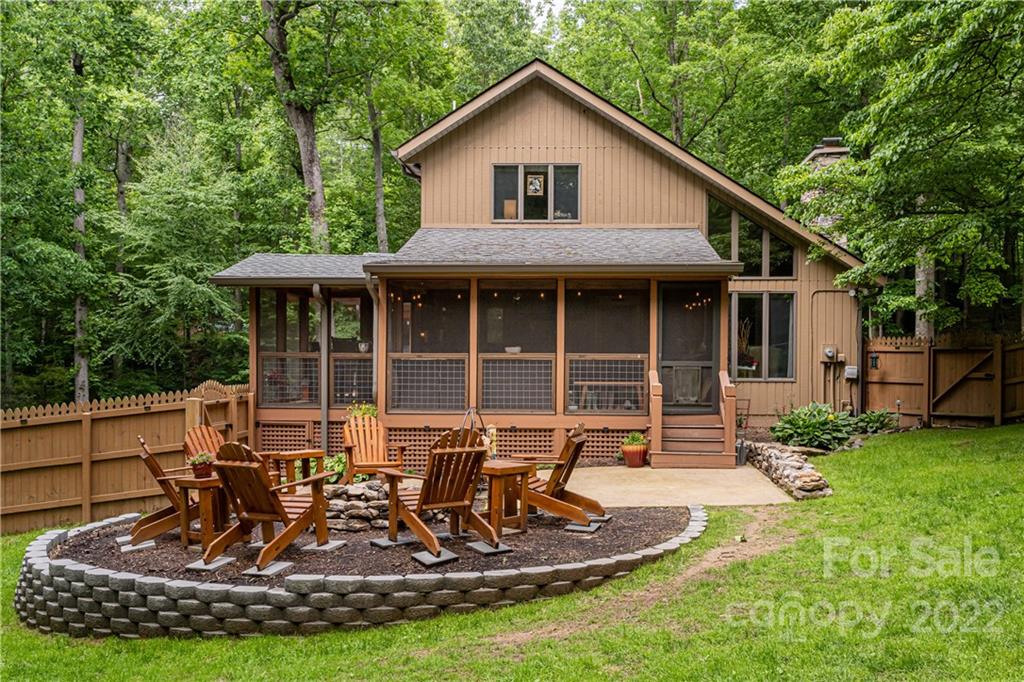 29 Spring Lane Fairview, NC 28730 - Photo 2 of 43 a view of a house with a yard chairs and floor to ceiling window
