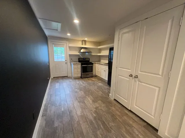 a view of empty room with wooden floor