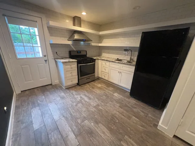 a kitchen with a sink wooden floor and stainless steel appliances