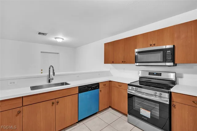a kitchen with stainless steel appliances a stove microwave and sink