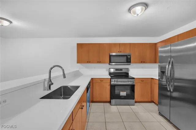a kitchen with stainless steel appliances granite countertop a sink and a refrigerator